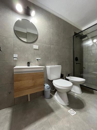 uma casa de banho com um WC, um lavatório e um espelho. em Departamento Pleno Centro de Córdoba Capital em Córdoba
