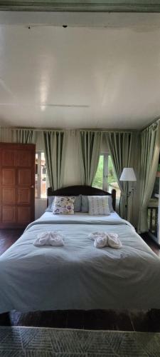 um quarto com uma cama grande com duas toalhas em Rumah D'Rhu, Zaki's Residence em Marang