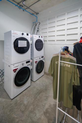 two washing machines sitting next to each other in a room at C'HOUSE Bangkok in Pom Prap
