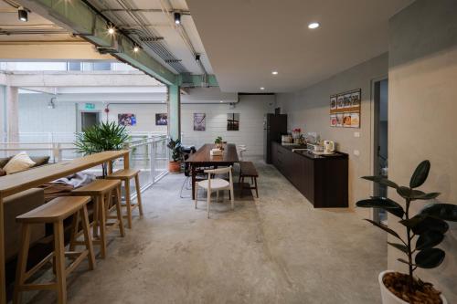 a restaurant with a table and chairs and a counter at C'HOUSE Bangkok in Pom Prap