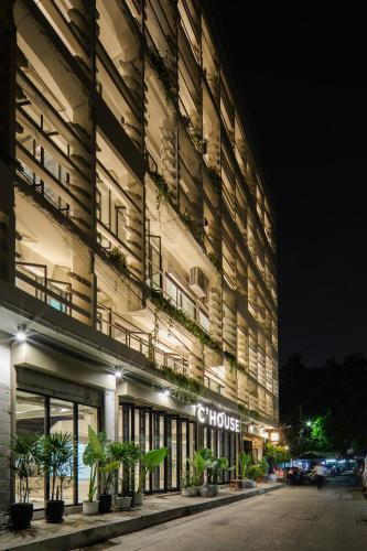 a large building with plants on the side of it at C'HOUSE Bangkok in Pom Prap
