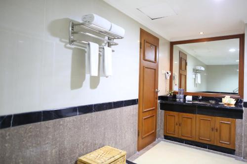 ein Bad mit einem Waschbecken und einem Spiegel in der Unterkunft Golden Boutique Hotel Melawai in Jakarta