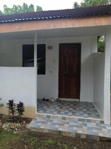 a house with a wooden door and a patio at Villa Tabitha in Panglao Island