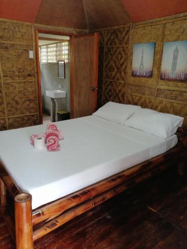 Cama en habitación con sábanas blancas en Villa Tabitha, en Panglao