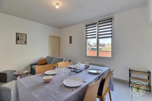 d'une salle à manger avec une table, des chaises et une fenêtre. dans l'établissement Les etangs, à Liffré