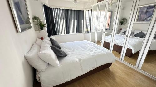 a bedroom with a bed and a couch with mirrors at Nyza's cosy House in Blackpool