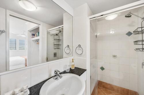 a white bathroom with a sink and a shower at Stunning 3-Bed Retreat in Marcoola with Pool & Gym in Marcoola