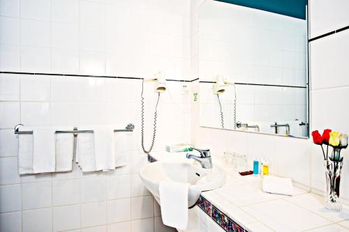 a white bathroom with a sink and a mirror at VR Hamilton in Hamilton