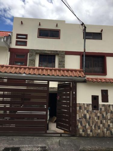 a house with a garage and a building with a gate at CASA LESLY in Cuenca