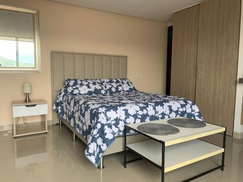 a bedroom with a bed with a blue and white bedspread at Apartamento Poblado Frontera in Medellín