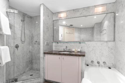 a bathroom with a tub and a sink and a shower at Quay West 2302 Self-Catering in Sydney