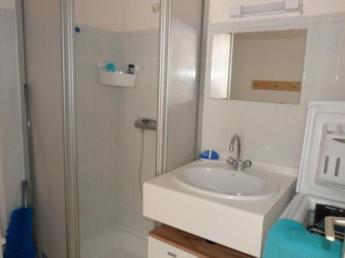 une salle de bain blanche avec un lavabo et une douche dans l'établissement Maisonnette 4 pers. près plage, piscine et parking - FR-1-194-260, à La Tranche-sur-Mer