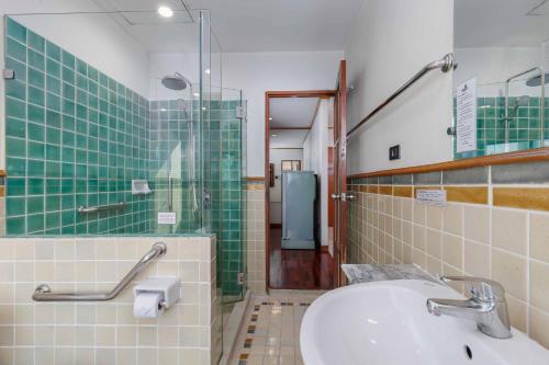 uma casa de banho com um lavatório e uma cabina de duche em vidro. em Charlie House Pin Klao em Bangkok
