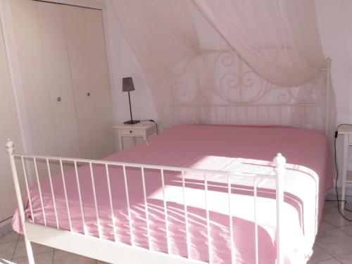 - un lit blanc avec un berceau blanc dans une chambre dans l'établissement Appartement 4 pièces, superbe vue mer, piscine, parking, animaux admis, Sainte-Maxime - FR-1-780-6, à Sainte-Maxime