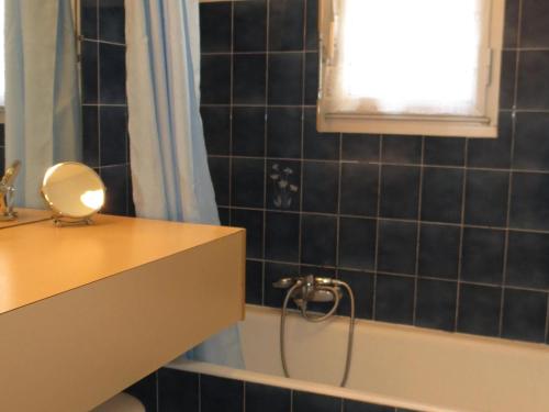La salle de bains est pourvue d'un lavabo, d'une baignoire et d'une fenêtre. dans l'établissement Appartement T2 calme avec parking, balcon, proche centre-ville et plage à Sainte-Maxime - FR-1-780-22, à Sainte-Maxime