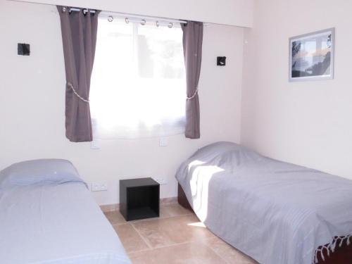 une chambre avec deux lits et une fenêtre dans l'établissement Appartement 2P refait à neuf avec clim et garage, piscine, proche commerces et plage à Sainte-Maxime - FR-1-780-21, à Sainte-Maxime