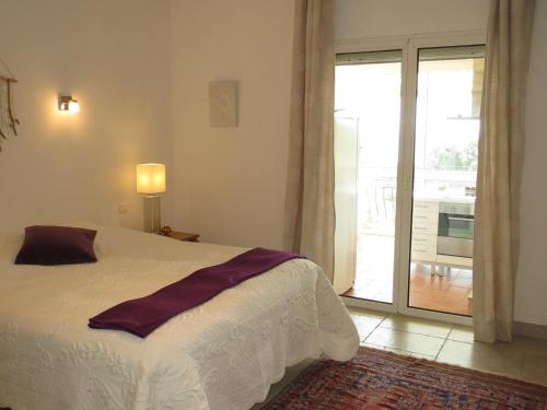 une chambre avec un lit et une porte coulissante en verre dans l'établissement Villa 5 pièces + appart, piscine privée, clim, proche plages - FR-1-780-16, à Sainte-Maxime