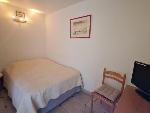 une chambre avec un lit, une chaise et une télévision dans l'établissement Studio Coin-Nuit avec Parking au Centre de Sainte-Maxime, Golfe de St-Tropez - FR-1-780-41, à Sainte-Maxime
