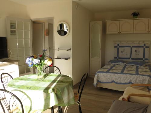 - une chambre avec un lit et une table fleurie dans l'établissement Studio avec piscine, climatisation et parking à 100 m du centre et plage - Sainte-Maxime - FR-1-780-49, à Sainte-Maxime