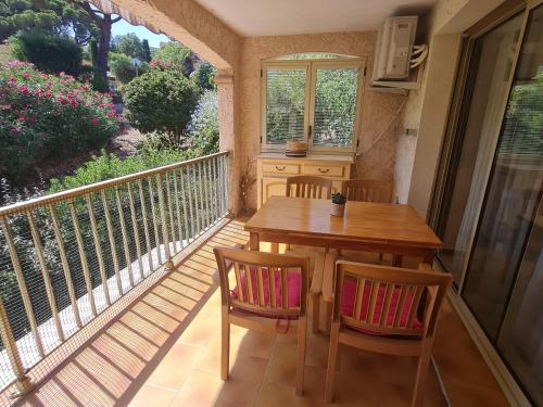 Elle comprend un balcon avec une table et des chaises en bois. dans l'établissement Sublime 2 Pièces avec Clim, Terrasse, Piscine et Parking Privé, Proche Plages et Commerces à Sainte-Maxime - FR-1-780-20, à Sainte-Maxime
