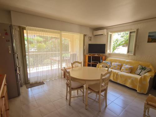 un salon avec une table et un canapé dans l'établissement Sublime 2 Pièces avec Clim, Terrasse, Piscine et Parking Privé, Proche Plages et Commerces à Sainte-Maxime - FR-1-780-20, à Sainte-Maxime