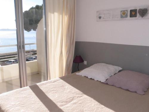 ein Schlafzimmer mit einem Bett mit Blick auf das Meer in der Unterkunft Appartement T2 face à la mer avec terrasse en centre-ville - Sainte-Maxime - FR-1-780-48 in Sainte-Maxime