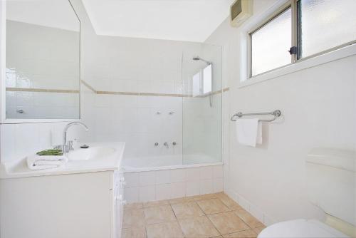a white bathroom with a sink and a shower at Cobden & Wills & Studio in Bright