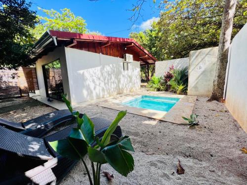 a backyard with a swimming pool and a house at Perro Loco Villas in Paraíso