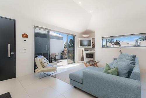 a living room with a blue couch and a chair at Chimneys On Bank in Port Fairy