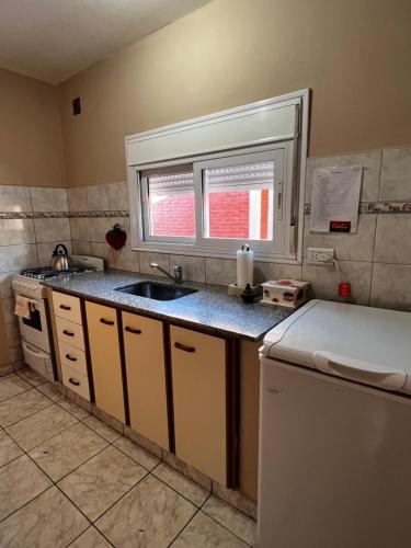 a small kitchen with a sink and a window at Alquiler temporario zapala Amanecer in Zapala