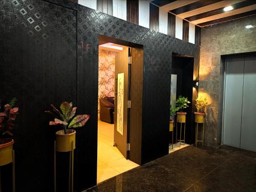 a hallway with a door and plants on the wall at StayVilla Royal Executive Rooms in Rānchī