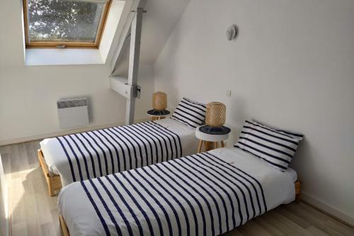 2 Betten nebeneinander in einem Zimmer in der Unterkunft Ty Kaouenn ARMOR in Plumergat