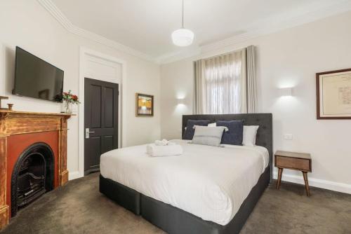 um quarto com uma cama com lareira e uma televisão em Sanlor Suite 2 - Luxury, Comfort & Style em Orange