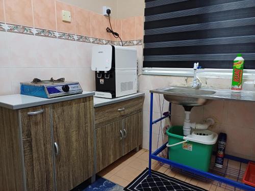 a small kitchen with a sink and a microwave at Homestay Wafiy Lost World Tambun Ipoh in Ipoh