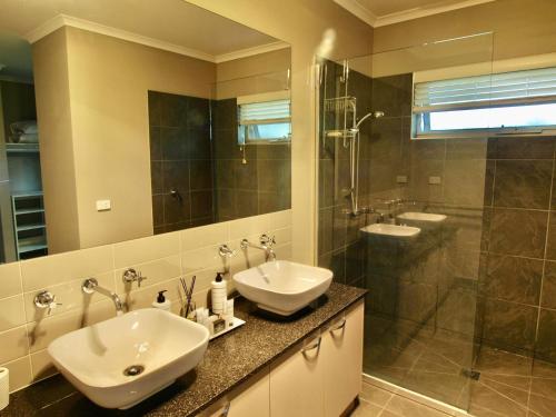 a bathroom with two sinks and a shower at Collins Retreat - 4 Bedroom home with Pool in Bright