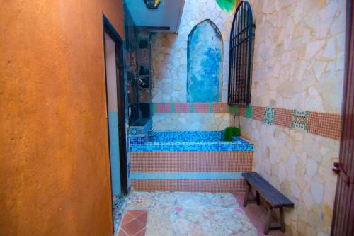 een betegelde badkamer met een bad en een bank bij Boutique Hotel Colonial in Santo Domingo