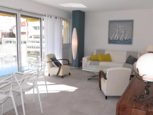 un salon avec un canapé et des chaises dans l'établissement Appartement 3 pièces avec terrasse, clim, wifi, garage en centre-ville à Sainte-Maxime - FR-1-780-57, à Sainte-Maxime