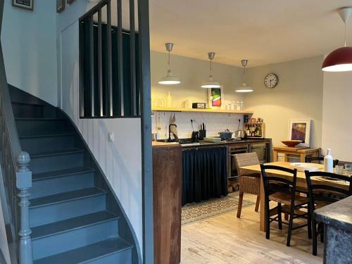 Un escalier mène à une cuisine et une salle à manger. dans l'établissement Charmante maison 3* près de la plage, jardin privé, WiFi, idéale pour découvrir la Côte de Granit Rose - FR-1-542-59, à Trégastel