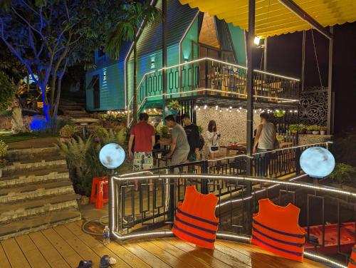a group of people standing at a bar at night at Hồ Mây Homestay in Bảo Lâm