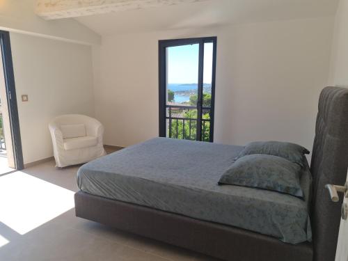 une chambre avec un lit, une chaise et une fenêtre dans l'établissement Villa climatisée 6 pièces avec piscine privée, 5 chambres, Domaine de La Nartelle - FR-1-780-67, à Sainte-Maxime