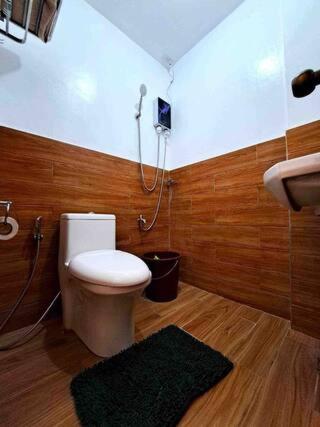uma casa de banho com um WC, um chuveiro e um lavatório. em Caishen Apartelle The Traveler Accomodation 