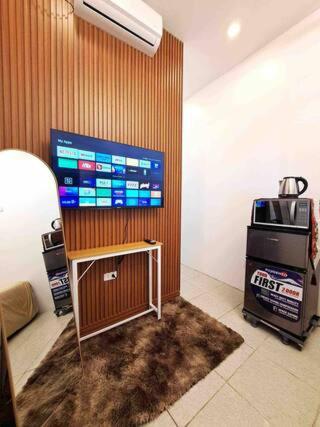 um quarto com uma televisão de ecrã grande num quarto em Caishen Apartelle The Traveler Accomodation 