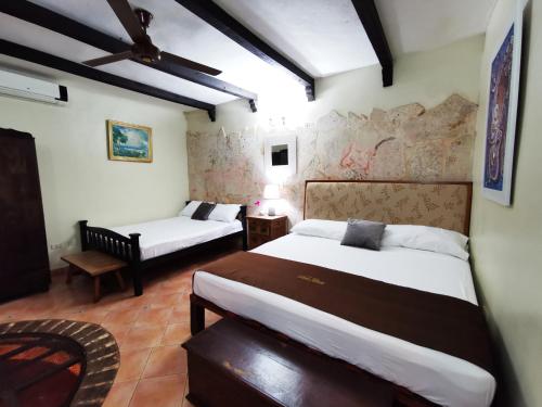 een slaapkamer met 2 bedden en een stoel. bij Boutique Hotel Colonial in Santo Domingo