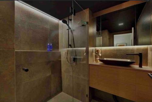 a bathroom with a glass shower with a sink at South Brisbane modern apartment in Brisbane