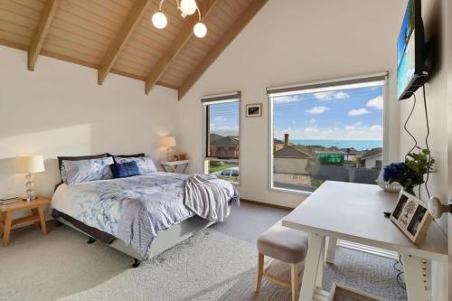 a bedroom with a bed and a desk and a window at Seven Views I Pool Table n Water Views in Clifton Springs