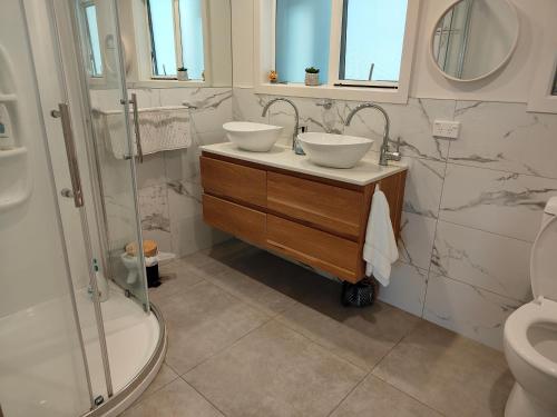 a bathroom with two sinks and a shower at Kerikeri Sunny Modern 2 Bedroom Apartment in Kerikeri