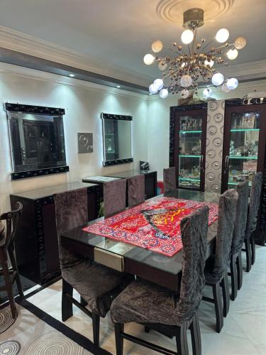 ein Esszimmer mit einem Tisch, Stühlen und einem Kronleuchter in der Unterkunft Home El Awhadi in Kairo