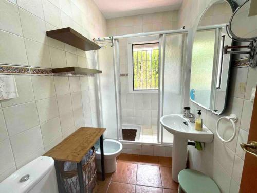 a bathroom with a toilet and a sink and a shower at 3 bedrooms chalet with shared pool terrace and wifi at Conil de la Frontera 7 km away from the beach in Hozanejos