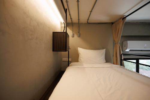 a small bedroom with a bed in a room at C'HOUSE Bangkok in Pom Prap