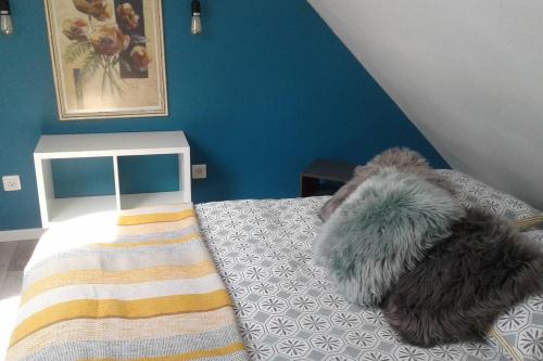 une chambre avec un lit avec un mur bleu dans l'établissement Appartement cosy Wintzenheim + terrasse, à Wintzenheim
